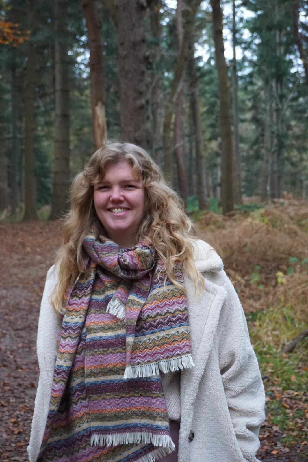 Fenna Dijkstra, in het bos met een kleurige sjaal om